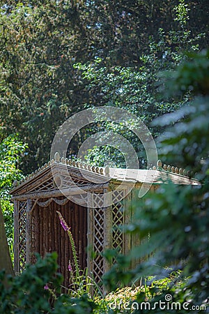 Secret summer house. Ornamental wooden trellis garden gazebo sea Stock Photo