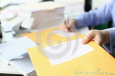 Secretary fills in address on yellow postal envelope for sending letters Stock Photo