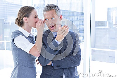 Secretive business colleagues whispering Stock Photo