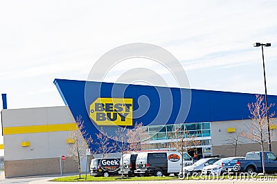 A section of Best Buy storefront seen with the Geek Squad vehicles parked in the parking lot. Editorial Stock Photo