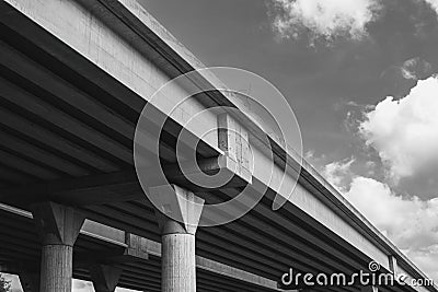 Section of newly constructed elevated highway.Shot against a bright blue sky.Black and white photography. Stock Photo