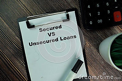 Secured Vs Unsecured Loans write on a paperwork isolated on Wooden Table Stock Photo
