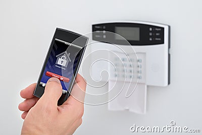 Security alarm keypad with person disarming the system Stock Photo