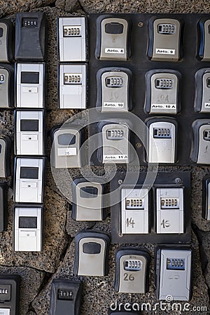 security boxes with password controlled locking for the storage of keys of holiday flats at the entrance of a building, problem of Stock Photo