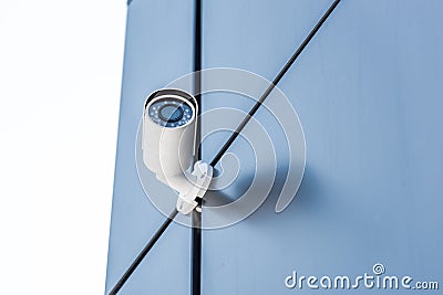 Security camera on blue wall of office building, security system concept Stock Photo