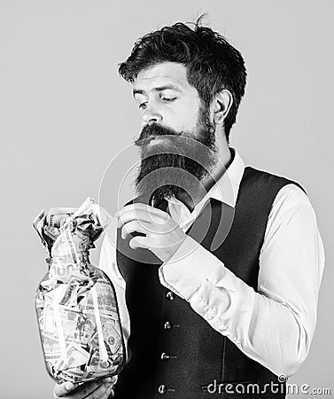 Security and cash money savings. Banking concept. Man bearded guy hold jar full of cash savings. Establish your budget Stock Photo