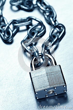 Unbreakable secure steel padlock and chain on steel surface Stock Photo