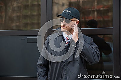 Security Guard In Front Of The Door Entrance Stock Photo