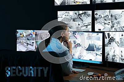 Security guard monitoring modern CCTV cameras at night Stock Photo