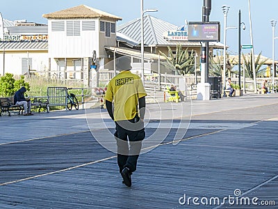 A security guard is seen from the back as he walks along the boardwalk in Atlantic City Editorial Stock Photo