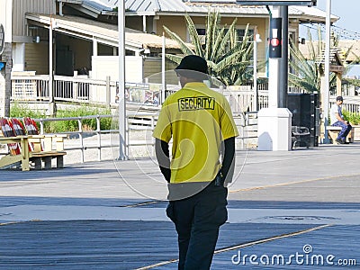 A security guard is seen from the back as he walks along the boardwalk in Atlantic City Editorial Stock Photo