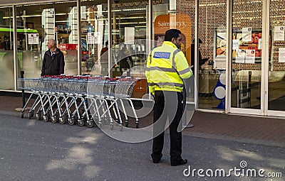 Security guard and shopping trolleys at a supermarket. Editorial Stock Photo