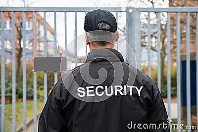 Security Guard Standing In Front Of Gate Stock Photo