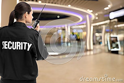Security guard using portable radio transmitter in shopping mall Stock Photo
