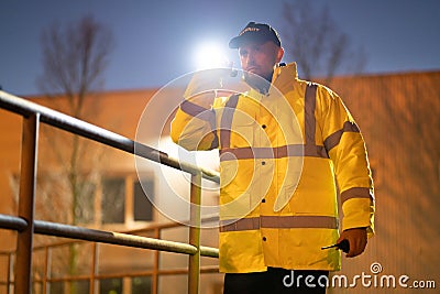 Security Guard Walking Building Perimeter With Flashlight Stock Photo