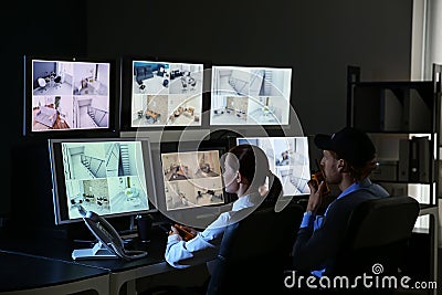 Security guards monitoring modern CCTV cameras in surveillance room Stock Photo