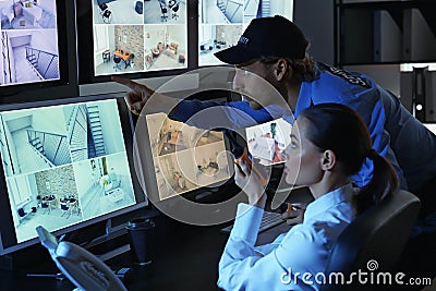 Security guards monitoring modern CCTV cameras in surveillance room Stock Photo