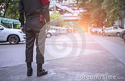 Security officers are facilitating traffic at the parking lot. Traffic officers are controlling traffic at the parking lot of the Stock Photo