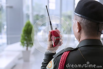 Security officers in green uniform are carrying radio communications during their duties. Editorial Stock Photo