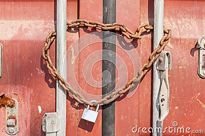 Security and Safety concept, a rusty metal chain and padlock wrapped around gateway entrance doors. Stock Photo