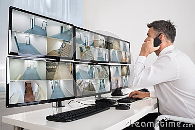 Security System Operator Looking At CCTV Footage Stock Photo