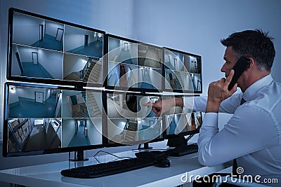 Security System Operator Looking At CCTV Footage Stock Photo