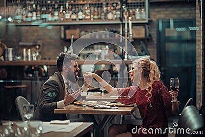 Seducing beautiful woman looking at her lover with wine glass. Having romantic talk. Stock Photo