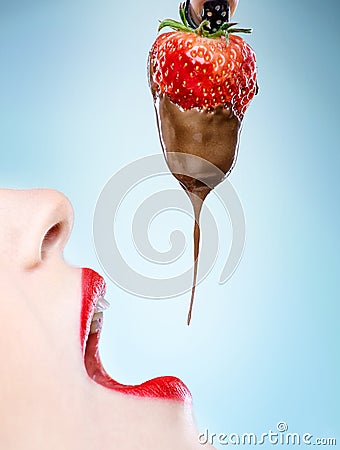 Seduction - red female lips eating chocolate strawberries Stock Photo
