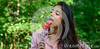 Seductive appetite. Woman full of desire eating tomato. Girl holds fork with juicy ripe tomato. Girl seductive eats red Stock Photo