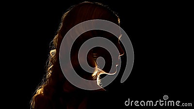 Seductive blond lady looking to side, isolated on black background, mystery Stock Photo