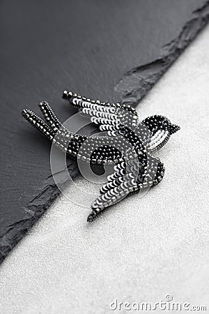 Seed bead embroidered brooch in a shape of black swallow bird Stock Photo