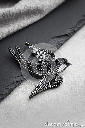 Seed bead embroidered brooch in a shape of black swallow bird Stock Photo