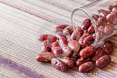 Seeds scattered from a jar on a gray board lie slide Stock Photo