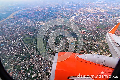 Seeing through airplane window and see overview city.Clouds in the sky and cityscapes though airplane window. Stock Photo