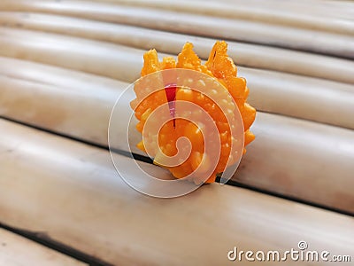 Seelctive Focus of Ripe Bitter Gourd Balsam Apple on Bamboo Surface Stock Photo
