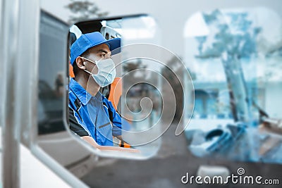seen from the window of a male driver in a uniform and wearing a mask while behind the wheel Stock Photo