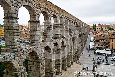 Aqueduct of Segovia. Ancient Roman aqueduct in the Plaza del Azoguejo and old construction cities in Segovia. Spain. Europe. Horiz Editorial Stock Photo