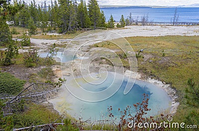 Seismograph pool with steamy water sits near Yellowstone Lake in Yellowstone National Park at West Thumb Geyser Basin. Stock Photo