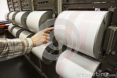 Seismograph recording earthquake human hand Stock Photo