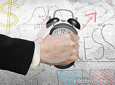 Seizing the time concept. Man hand holding alarm clock Stock Photo