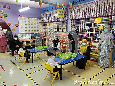 Standard 1 students are attending school by following the SOP of the Malaysian Ministry of Health at Editorial Stock Photo