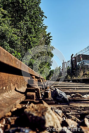 Seldom used, weathered railway line that is gradually overgrown by plants. Stock Photo