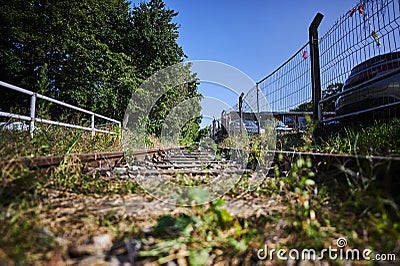 Seldom used, weathered railway line that is gradually overgrown by plants. Stock Photo