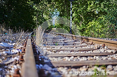 Seldom used, weathered railway line that is gradually overgrown by plants Stock Photo