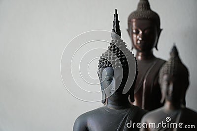 Select focus of vintage black ancient buddhas statue in the middle of other buddhas statue. Stock Photo