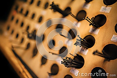 Selection of bicycle spokes on a wooden wall in a bicycle service. Stock Photo