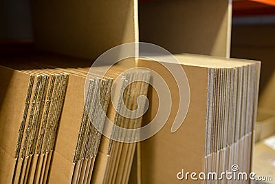 A selection of flat shipping boxes/cartons on a shelf ready to be made up and packed with product. Warehouse, despatch, shipping, Stock Photo