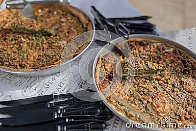 Selection of freshly-baked pies arranged on white paper with knives, ready to be enjoyed Stock Photo