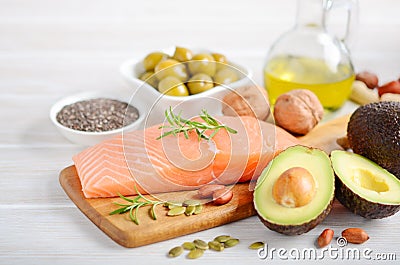 Selection of healthy unsaturated fats, omega 3 - fish, avocado, olives, nuts and seeds. Stock Photo