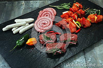 Selection of marinaded meat for bbq grilling with herbs on table Stock Photo